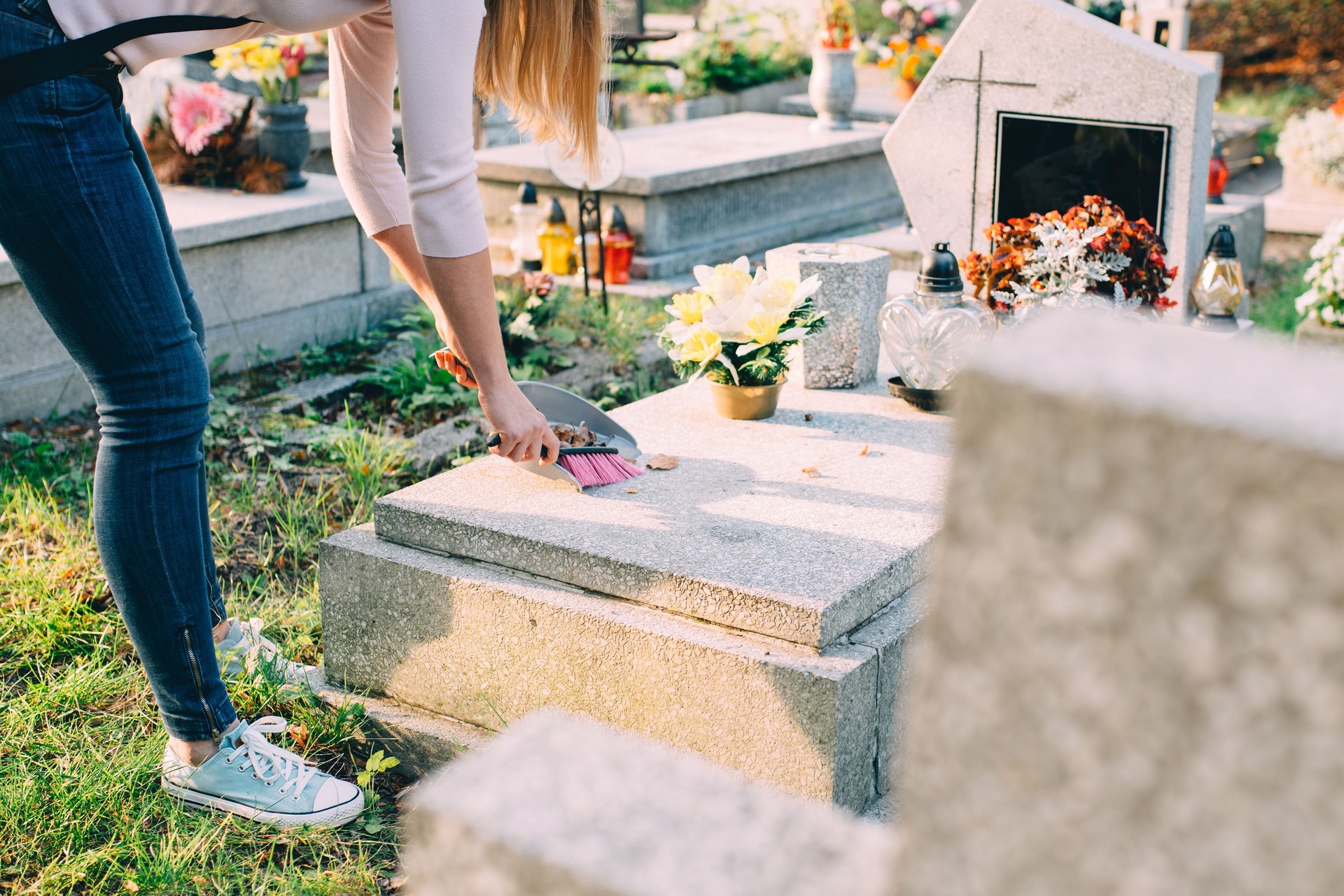Woman cleans the grave.