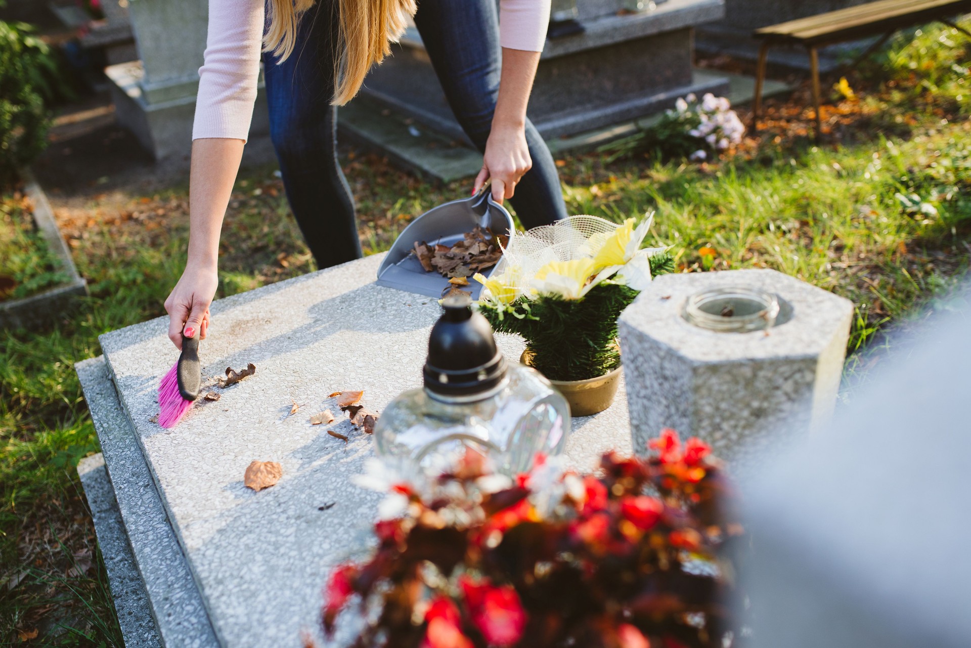 Woman cleans the grave.